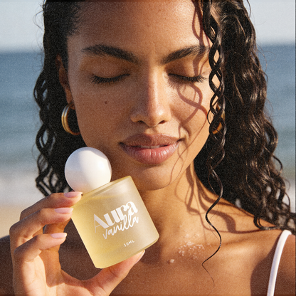 Femme souriante tenant le flacon Aura Vanilla contre sa joue