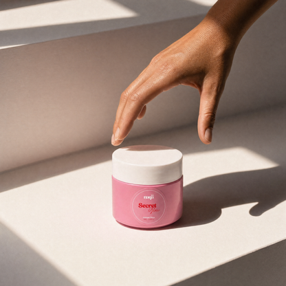 Main au-dessus du pot Secret Glow posé sur une surface ensoleillée