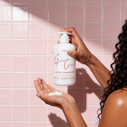 Femme versant l'après-shampooing Good Curls dans sa main, carrelage rose